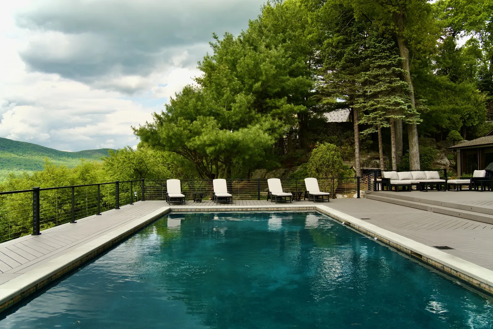 Infinity-edge pool and deck lounge with a mountain view
