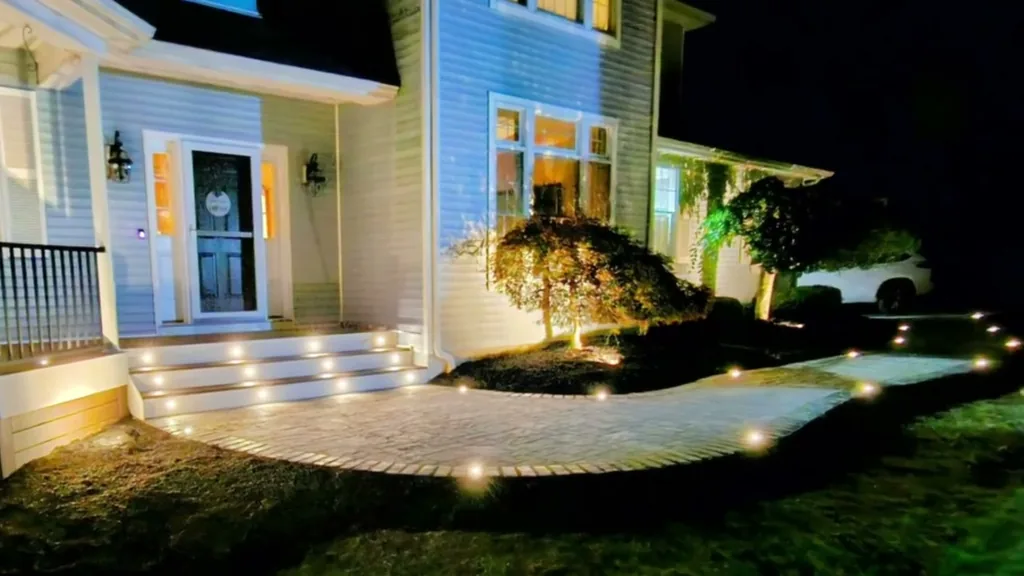 Night-lit paver entry walkway with landscape lighting